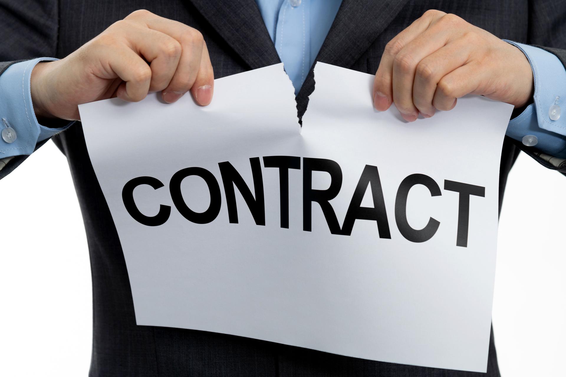 Businessman tearing paper with word contract